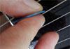 Guitar with hand showing hybrid picking